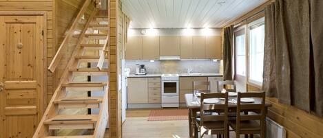 Un interno in legno con una scala, una cucina e una sala da pranzo.