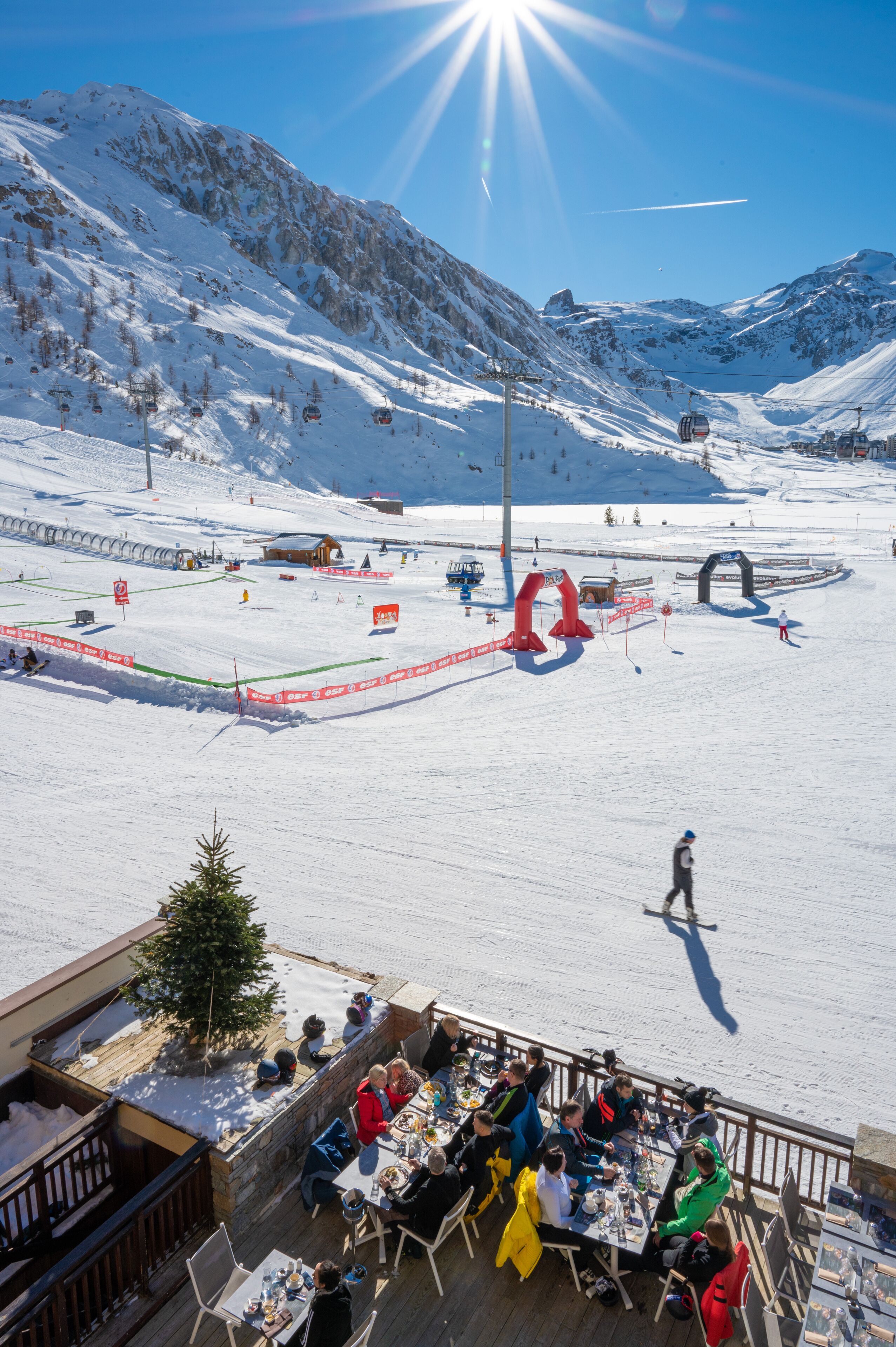 Ein mit Schnee bedeckter Skipisten mit einer Gastgehgegend mit Blick auf die Landschaft.