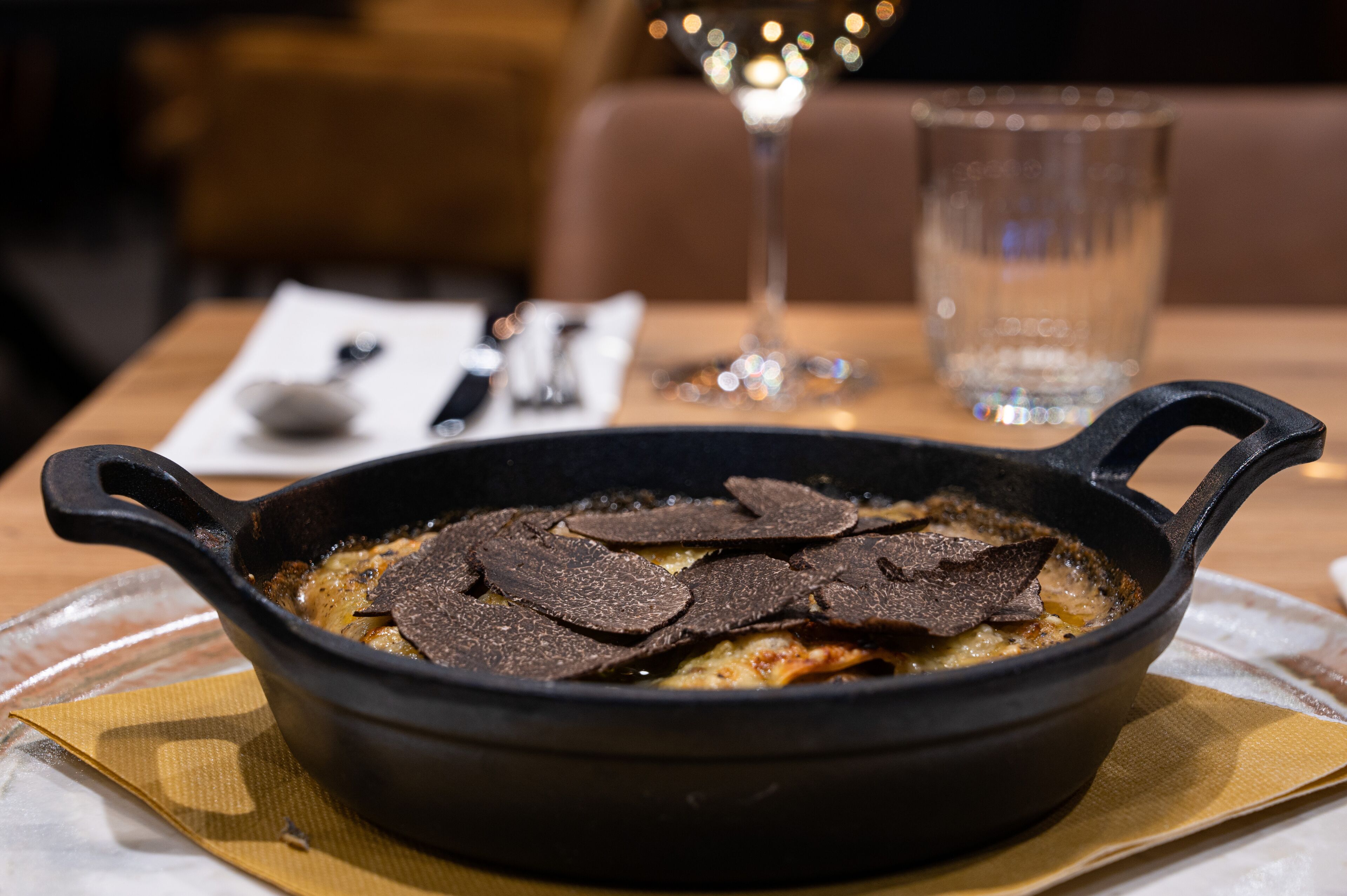 Een zwarte gietijzeren pan met stukjes chocolade op een tafel.