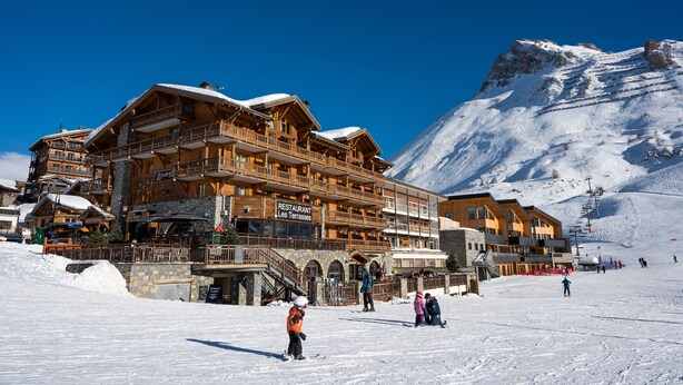 A large wooden building with multiple balconies and a sign that reads "Restaurant Les Terrasses." - Hôtel Le Levanna by Les Etincelles (Tignes)