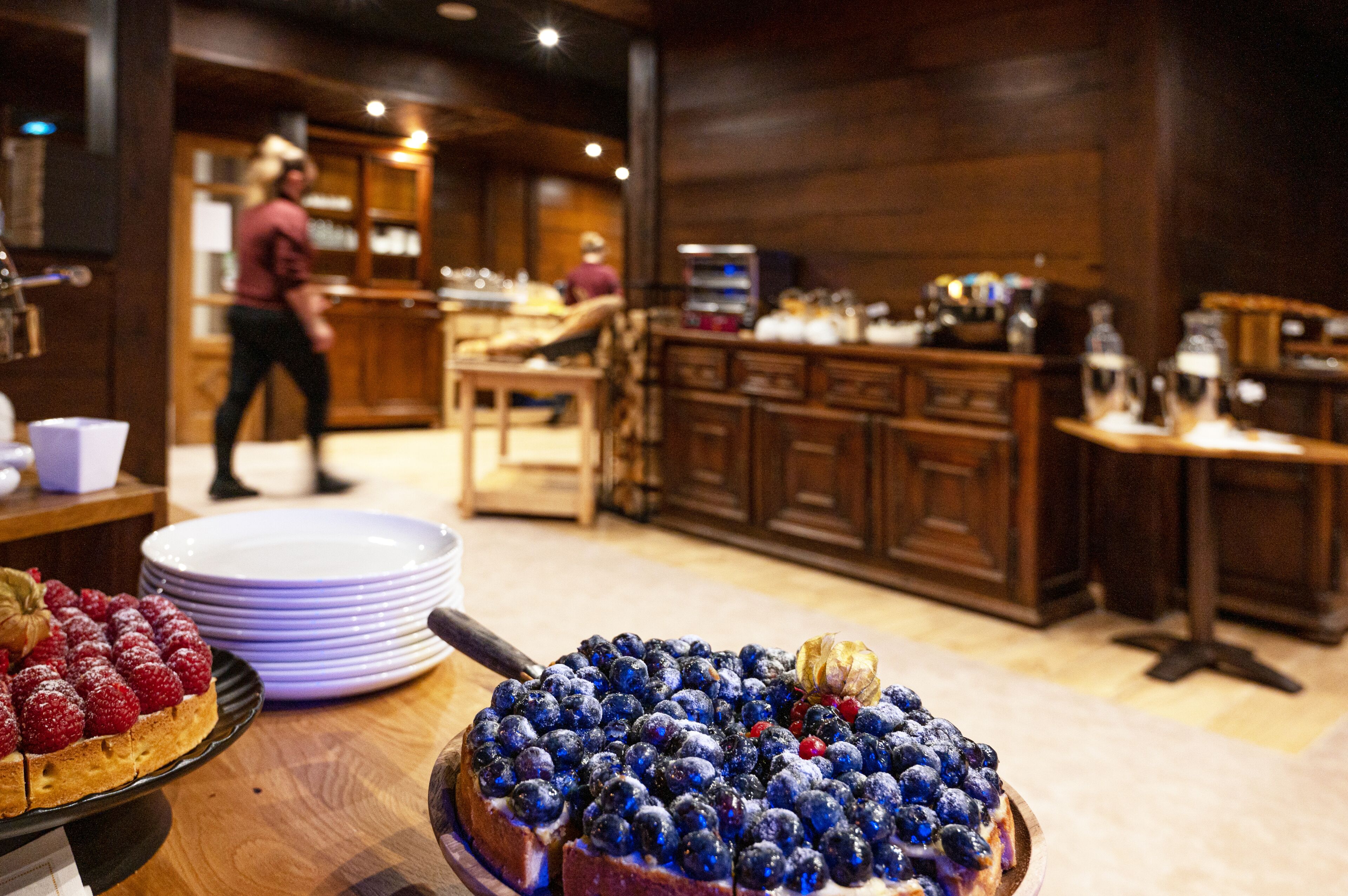 A buffet area with a variety of desserts, including a blueberry tart and a fruit tart.