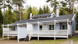 A two-story cabin with a porch, a chimney, and a deck. - Holiday Club Airisto (Pargas)