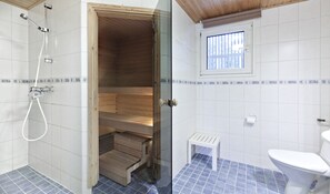 A bathroom with a shower, a toilet, and a small window. - Holiday Club Airisto (Pargas)