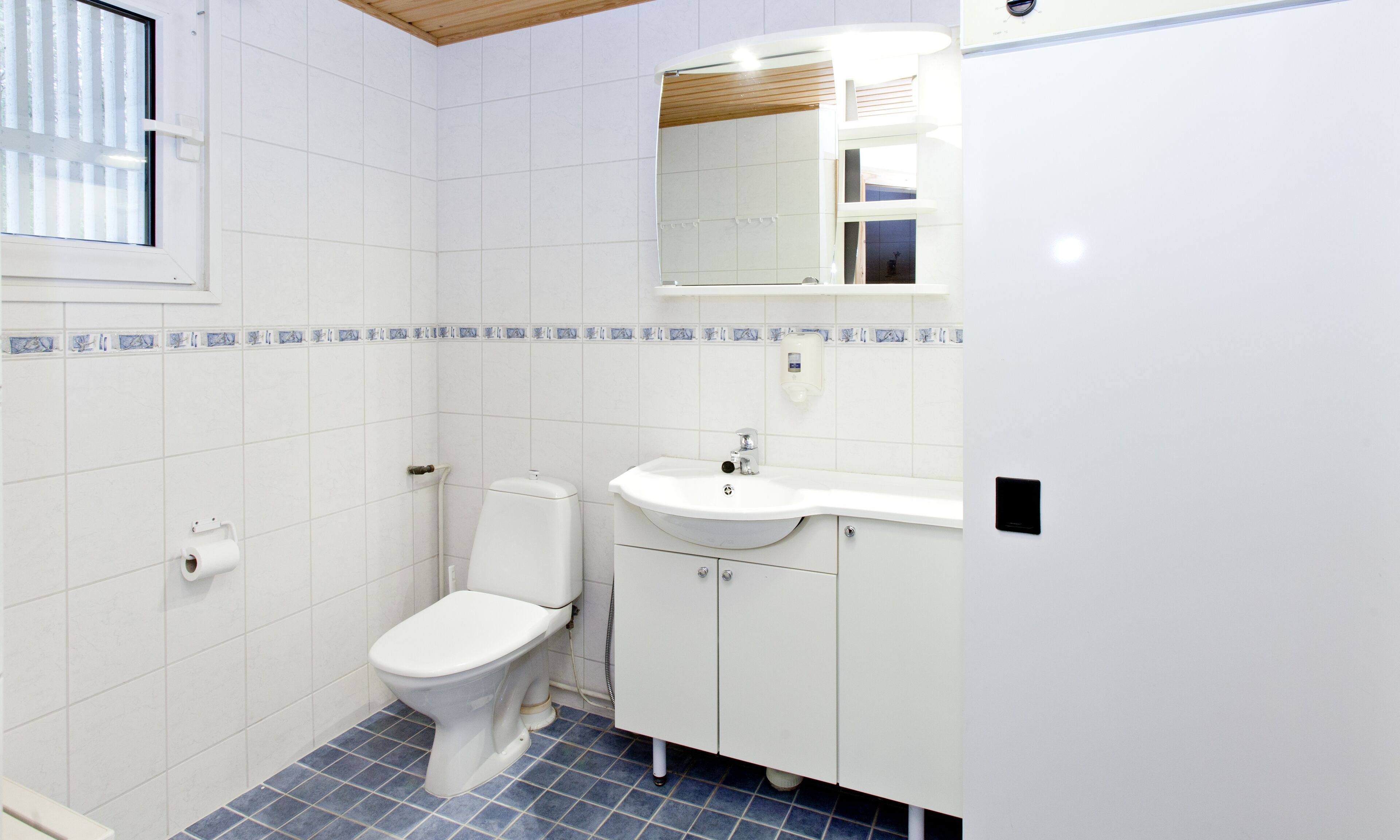Une salle de bain avec des toilettes, un lavabo et un miroir.