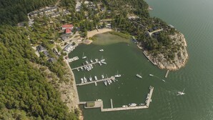 An aerial view of a marina surrounded by dense forest, with several boats docked and a small pier extending into the water. - Holiday Club Airisto (Pargas)