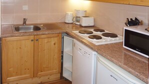A kitchen with wooden cabinets, a stainless steel sink, a dishwasher, a microwave, and a stove. - Les Orres 1800: apt for 6, heated pool, sauna, ski-in/ski-out (Les Orres)