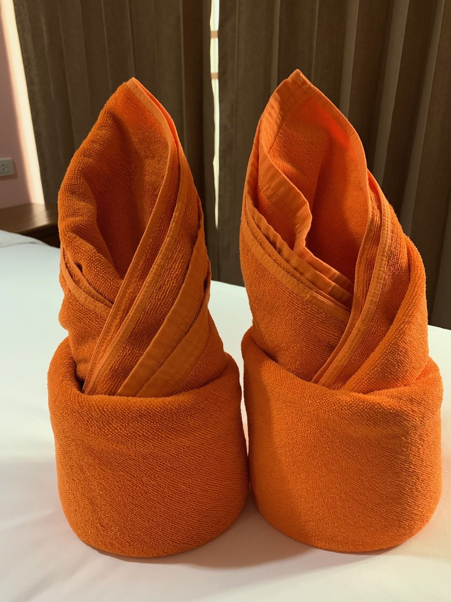 A pair of orange slippers on a white surface.