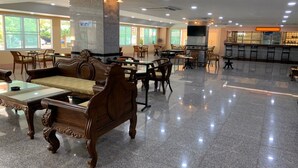 A spacious indoor area with a central column, multiple seating arrangements, and a food and drink counter. - A.A. Pattaya Golden Beach Hotel (Pattaya)