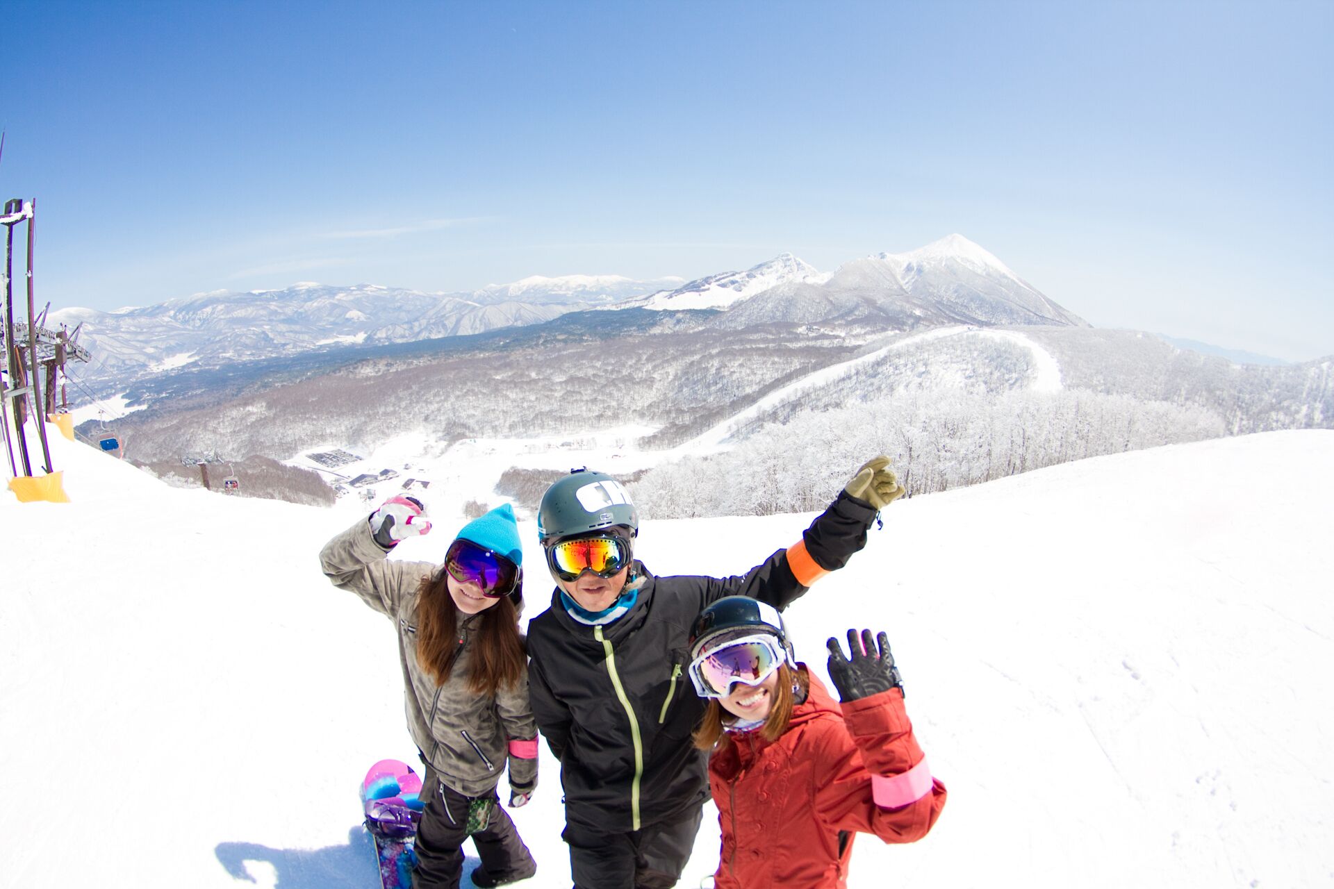 A snowy mountain landscape with a ski lift and a clear sky.