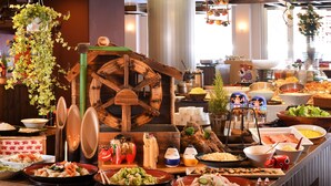 A buffet with various dishes, a large wooden wheel decoration, and hanging plants. - Urabandai Lakeresort Nekomarikyu (Kitashiobara)