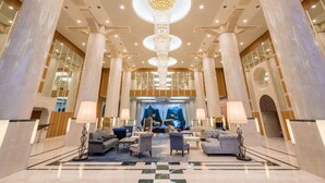 A spacious lobby with high ceilings, large columns, and a chandelier. - Urabandai Lakeresort Nekomarikyu (Kitashiobara)