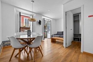 A modern interior with a dining area, a sofa, and a walk-in closet.