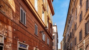 A narrow street with historic buildings, a gelato shop, and a visible storefront. - Bq House Trevi Luxury Rooms (Rome)