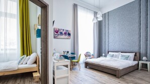 A modern bedroom with a wooden bed, a desk, and a chair, a small table with a lamp, and a patterned wall. - Budapest Passage 1 (Budapest)