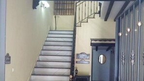 Una escalera conduce a un descansillo con un letrero que dice "POSADA RUSCO".