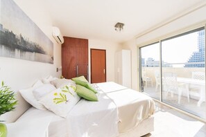 Una camera d'albergo con un letto, un'ampia finestra e vista sulla città.