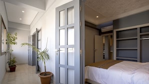 A bedroom with a bed, a potted plant, and a door leading to another room. - BNB Medina (Marrakech)