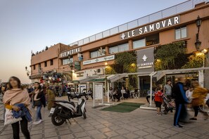 A busy urban street with a pharmacy and a restaurant named "Le Samovar". - BNB Medina (Marrakech)