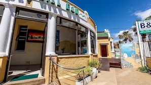 A building with a curved facade, large windows, and a sign indicating a B&B.