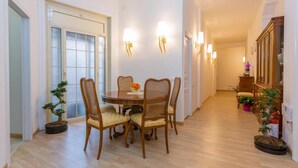 Un comedor con una mesa redonda, cuatro sillas y luces fijadas a la pared.