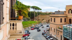 Una bulliciosa calle urbana con arquitectura histórica, un puente arqueado destacado y una mezcla de edificios modernos y tradicionales.