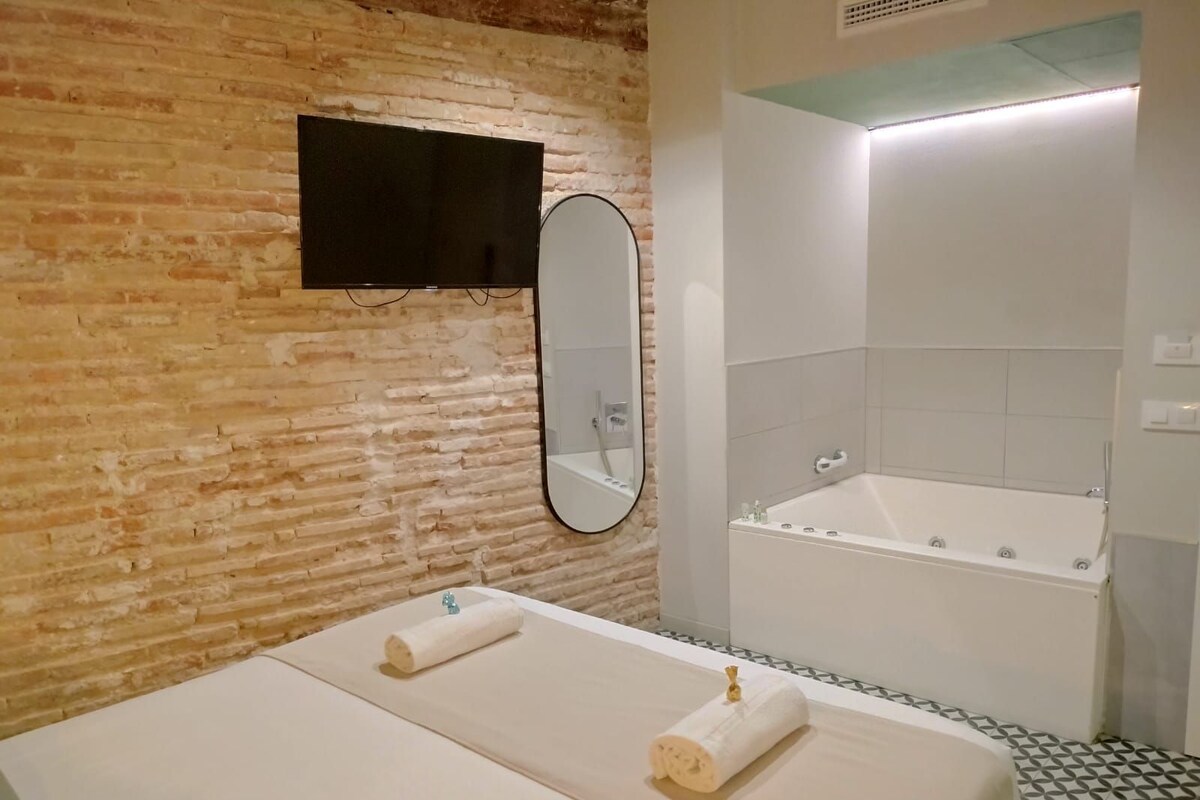 Uma casa de banho com parede de tijolos, um espelho, uma pia e uma banheira.