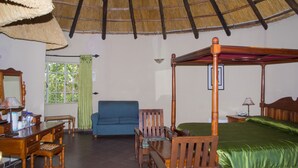 A room with a four-poster bed, a desk with a chair, a sofa, and a window with green curtains. - Macheke Lodges & Conference Centre (Macheke)