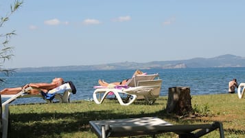 Spiaggia privata, sabbia scura, lettini da mare