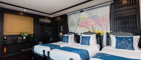 A hotel room with two beds, dark wood furniture, a large window with a view, and a painting on the wall.