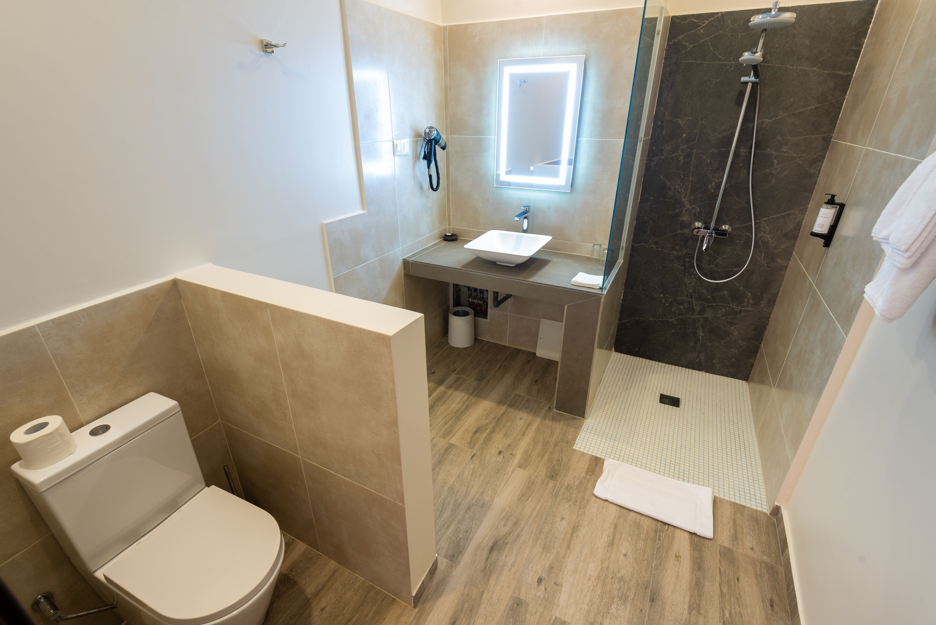 A modern bathroom with a toilet, sink, and shower.