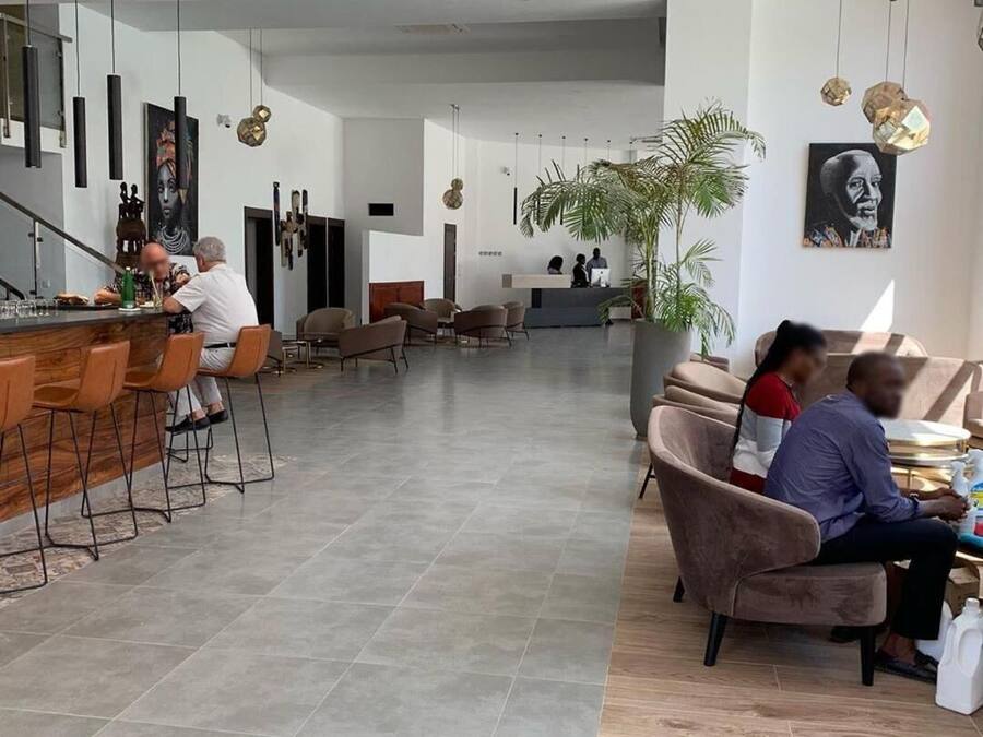 Um lobby de hotel moderno com área de bar, assentos e balcão de recepção.