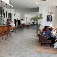 Un moderno vestíbulo de hotel con zona de bar, asientos y mostrador de recepción.