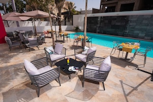 Una piscina al aire libre, tumbonas