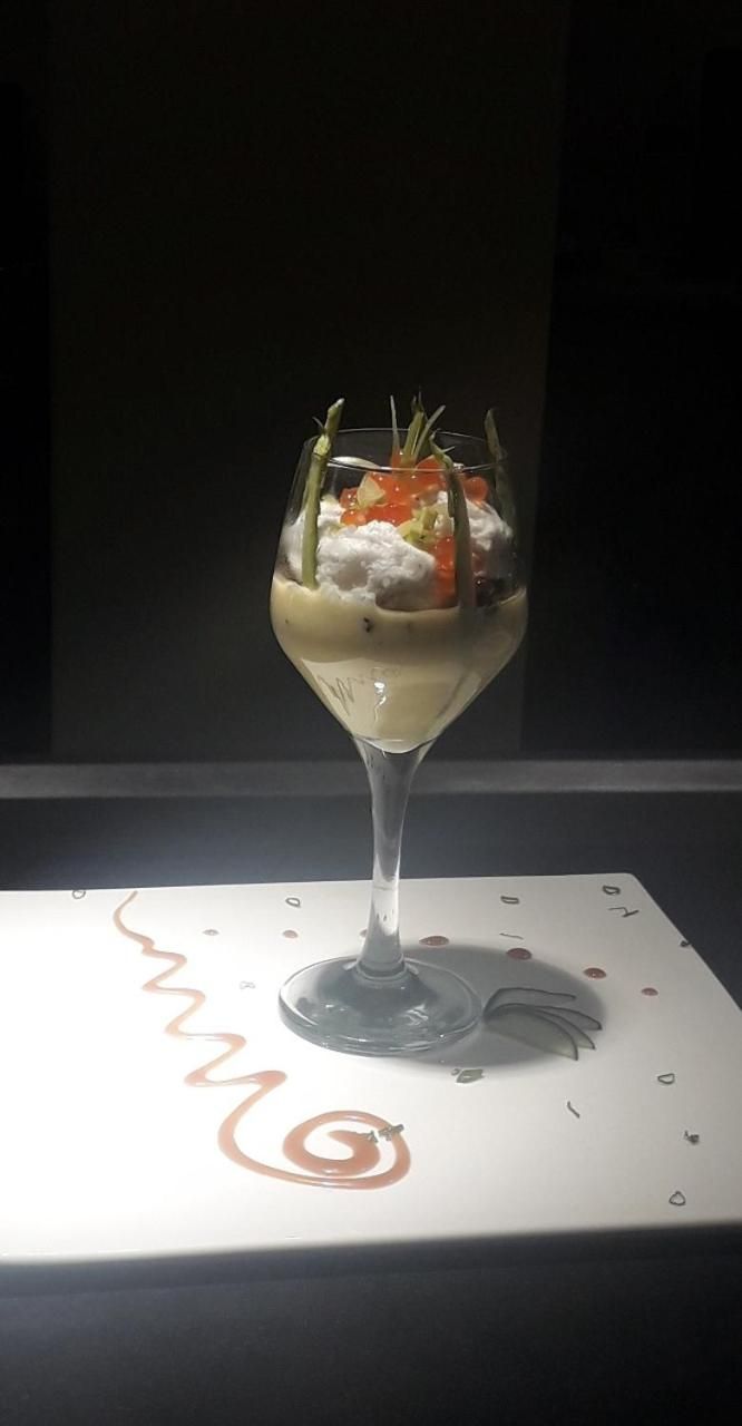 A dessert in a glass on a table with a card underneath.