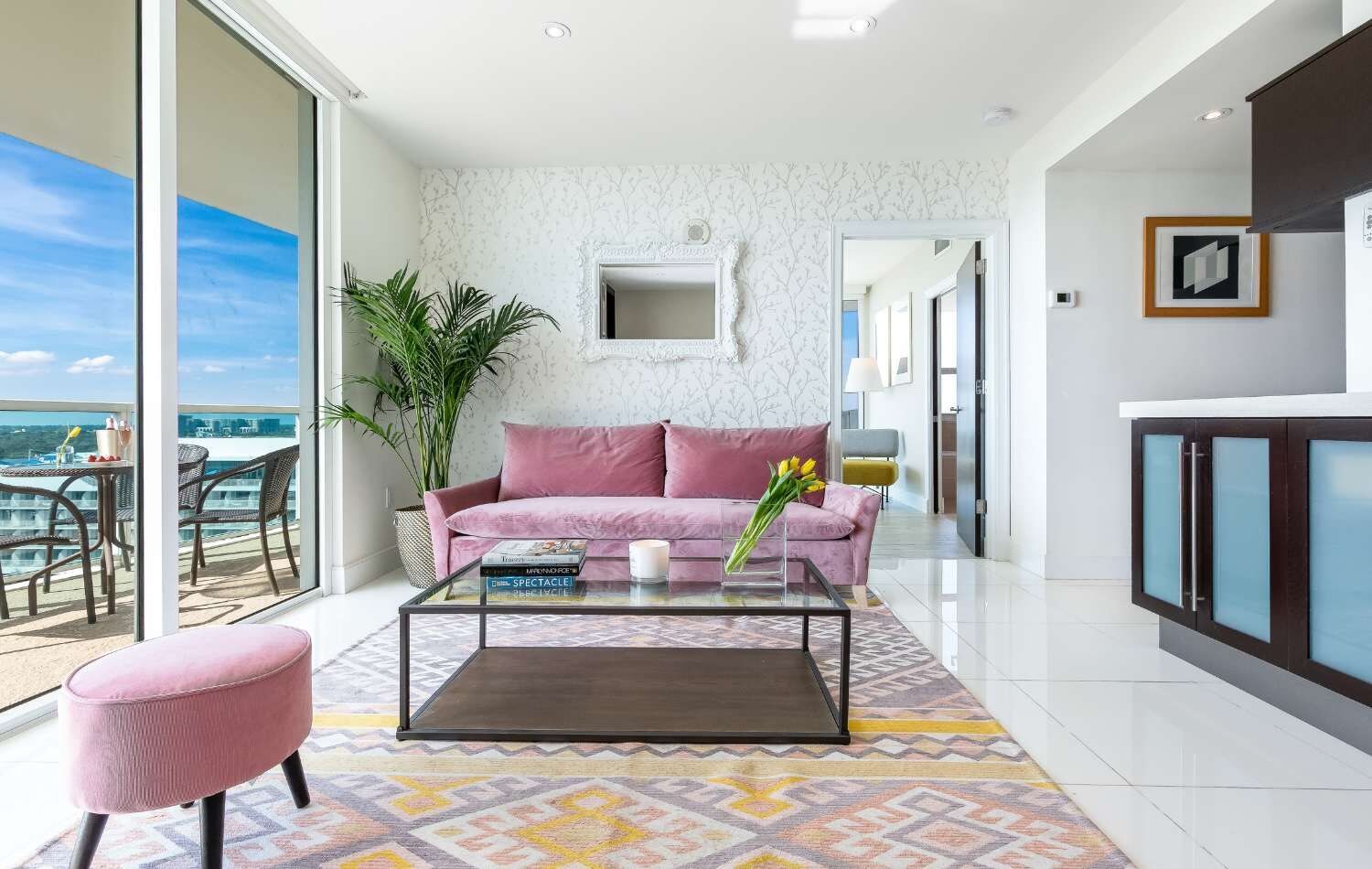 A modern living room with a sofa, coffee table, and a view of the sea.