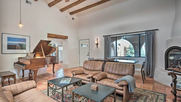 A spacious living room with a grand piano, leather sofas, and a fireplace. - Walk to Santa Fe Plaza & Shops! Adobe Gem w/ Patio (Santa Fe)