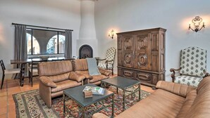 A living room with a sofa set, a coffee table, a patterned rug, a wooden cabinet, and a fireplace. - Walk to Santa Fe Plaza & Shops! Adobe Gem w/ Patio (Santa Fe)