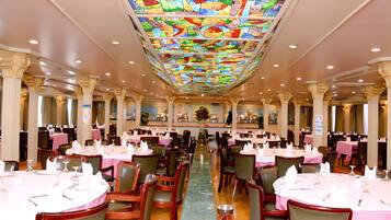 A spacious dining area with multiple tables, chairs, and a central aisle.