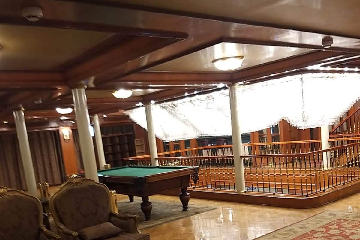 Een biljartruimte met een pooltafel, zachte zitplaatsen en uitzicht op het buitengebied.