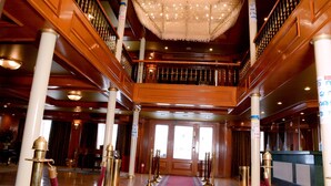 A grand lobby with a red carpet, wooden columns, and a chandelier. - MS King Tut I Nile Cruise (Luxor)