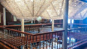 A spacious indoor area with a wooden floor, a railing, and a ceiling covered with a patterned fabric. - MS King Tut I Nile Cruise (Luxor)
