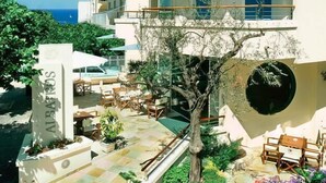 A multi-story hotel with outdoor seating and a tree in the courtyard. - Hotel Albatros (Misano Adriatico)