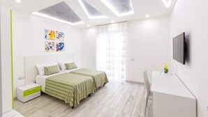 Un dormitorio moderno con cama, mesitas de noche, escritorio y televisor.