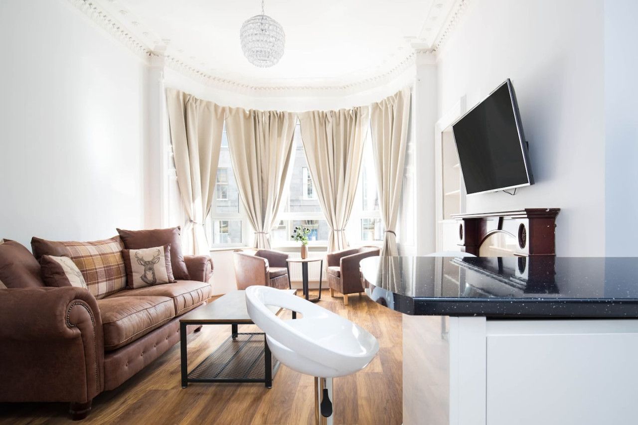 A modern living room with a sofa, coffee table, and a television mounted on the wall.