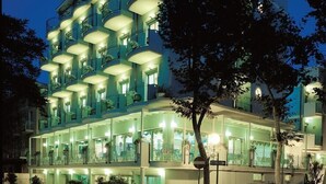 A multi-story hotel with balconies and a ground floor restaurant.