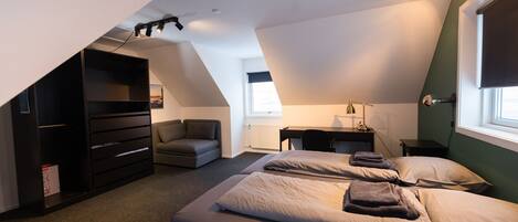 A modern bedroom with a loft bed, a desk, and a chair.