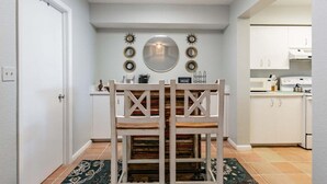 Una cocina compacta con armarios blancos, una encimera blanca y un horno empotrado.