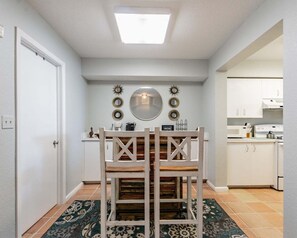 Eine kompakte Küche mit weißen Schränken, einer weißen Arbeitsplatte und einem eingebauten Backofen.
