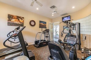 Ein Heimfitnessraum mit Laufbändern, Crosstrainern und Gewichtstrainern.