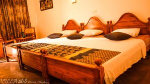 A wooden four-poster bed with a patterned bedspread and pillows, a nightstand with a lamp, and a window with curtains. - Located in Hikkaduwa, a 2-minute walk from town and supermarket hikkaduwa beach (Hikkaduwa)